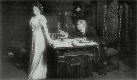 [Photo, from the play,
of Mr. Ryder discussing his son with Miss Green.]