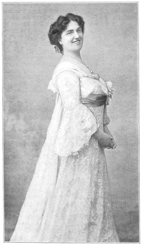 full-length photo, body facing right, smiling face to viewer