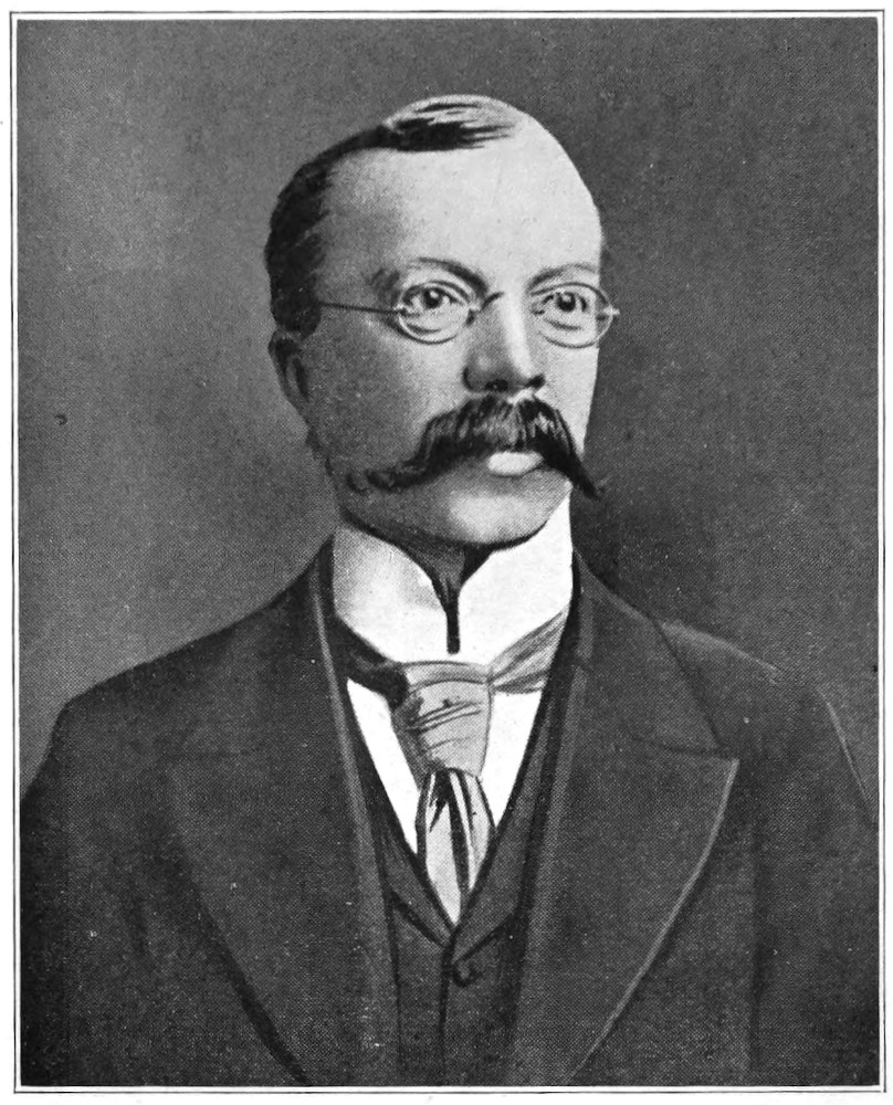 portrait, head and torso, of man wearing suit and cravat