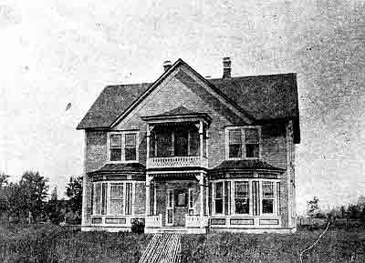 Two story frame house with gables and two chimneys; stacked covered porches.