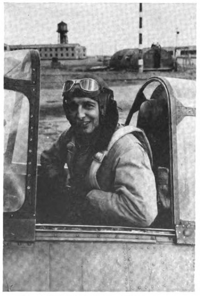 A young pilot in an an open air airplane