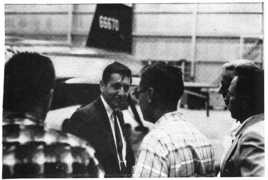 A group of men with a plane in the background