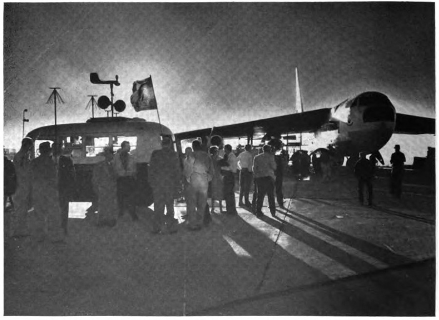 A crowd of people with an airplane in the background